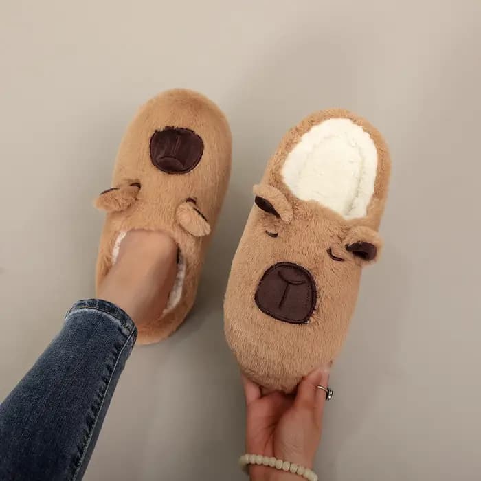Une paire de pantoufles d'intérieur en fourrure à motif animal capybara marron, confortables et chau